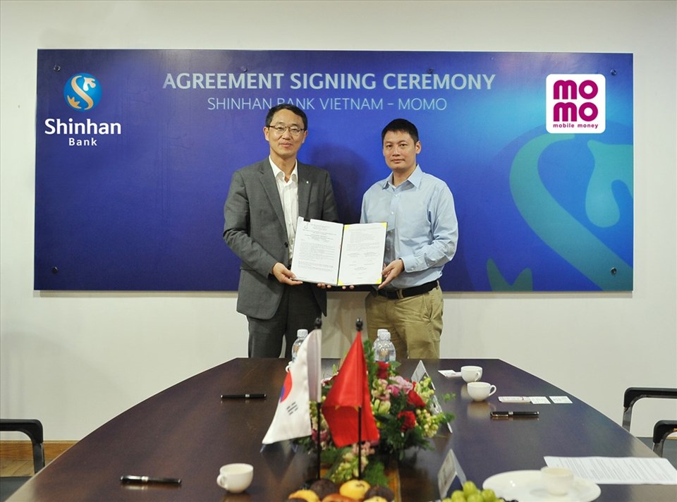 Ông Shin Dong Min - Tổng Giám đốc của Ngân hàng Shinhan Việt Nam, và ông Nguyễn Mạnh Tường - Giám đốc điều hành Ví MoMo, tại buổi lễ ký kết Ông Shin Dong Min - Tổng Giám đốc của Ngân hàng Shinhan Việt Nam, và ông Nguyễn Mạnh Tường - Giám đốc điều hành Ví MoMo, tại buổi lễ ký kết