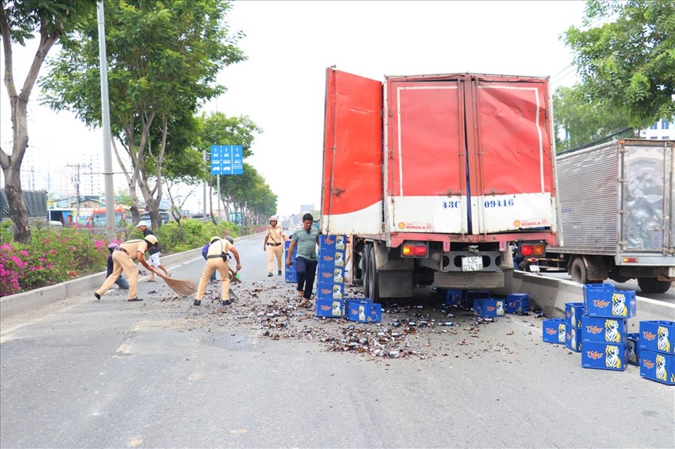 Hàng chục thùng bia rơi xuống làm QL1 ùn ứ nghiêm trọng. Ảnh: T.S Hàng chục thùng bia rơi xuống làm QL1 ùn ứ nghiêm trọng. Ảnh: T.S