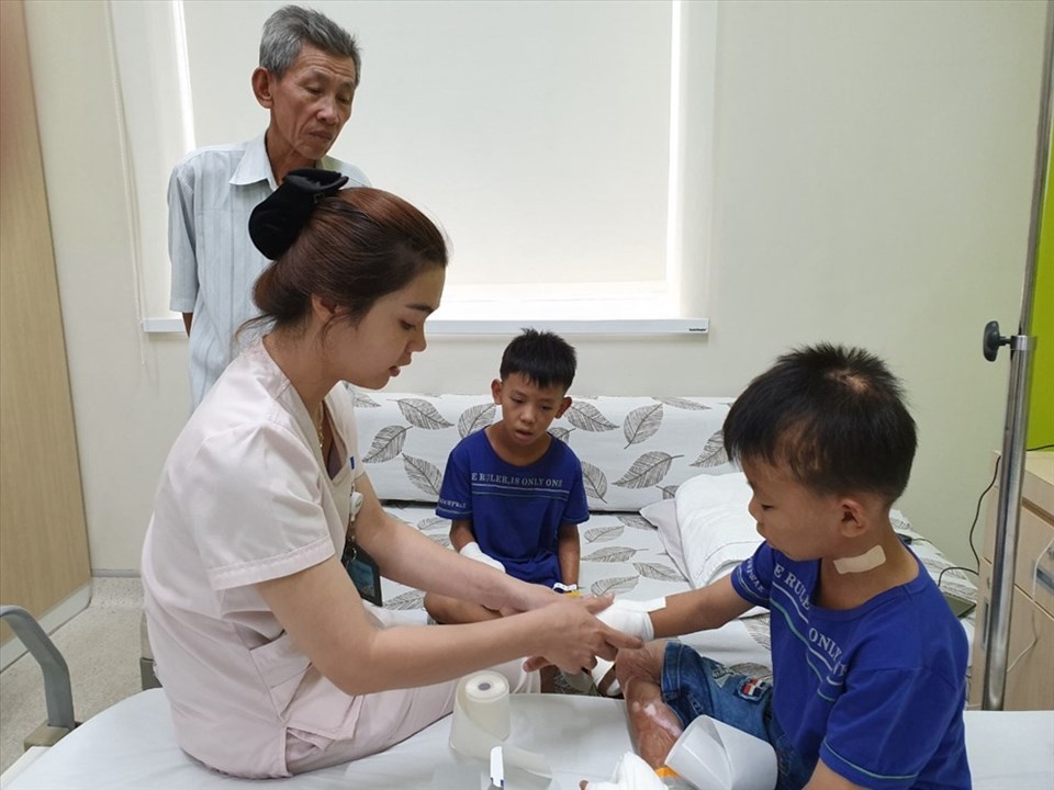 Điều dưỡng đang thay băng cho bé. Điều dưỡng đang thay băng cho bé.