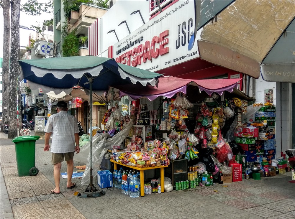 Quán tạp hóa “mọc” ngay trên vỉa hè đường Nguyễn Huy Tự (P. Đa Kao, Q.1). Đủ thứ hàng hóa được bày trên vỉa hè và trên các kệ. Ảnh: M.Q