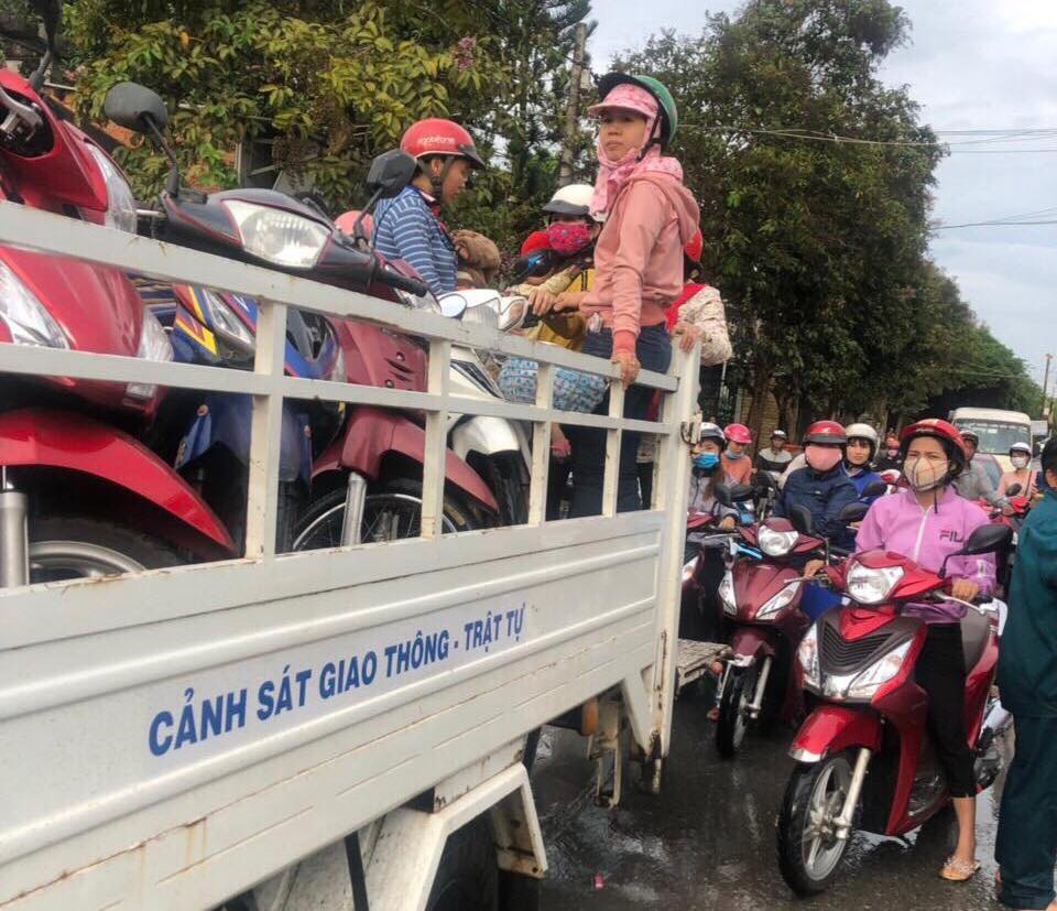 Người dân được đưa lên xe của cảnh sát giao thông để di chuyển qua đoạn đường ngập nước.