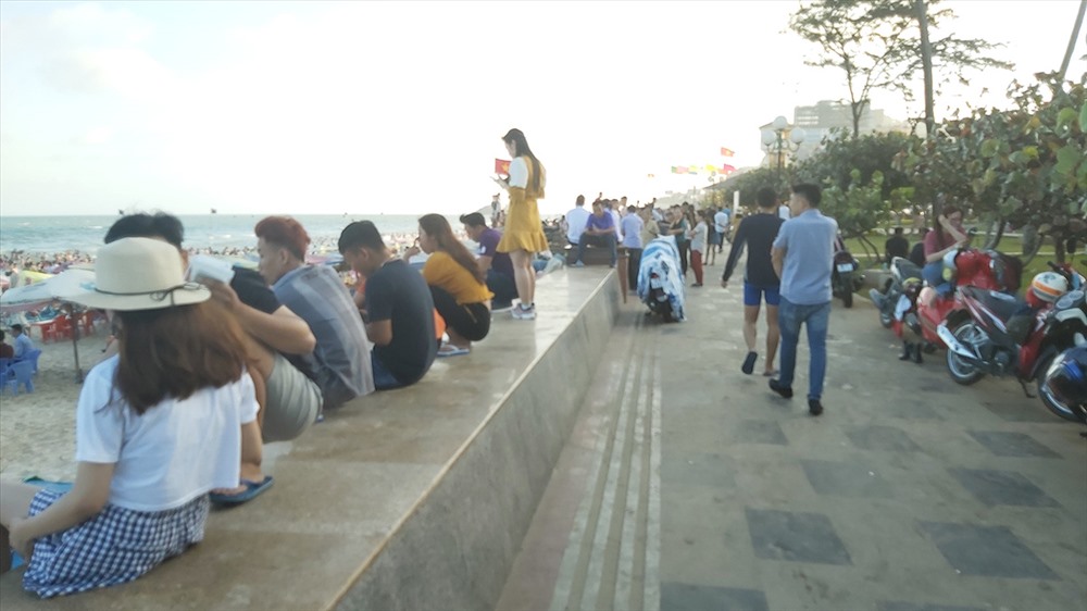 Nhiều bạn trẻ chọn giải pháp ngồi trên ngắm biển thay vì xuống tắm. Ảnh: QUỲNH NHƯ