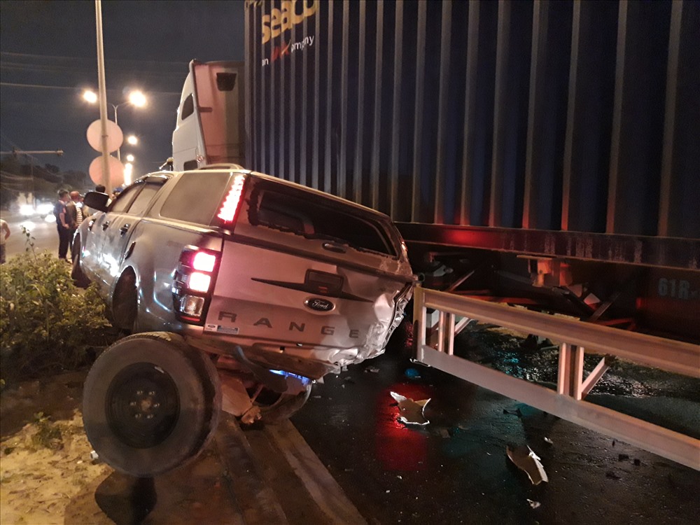 Một xe bán tải bị ép lên con lươn giữa đượng, văng 2 bánh sau ra ngoài.