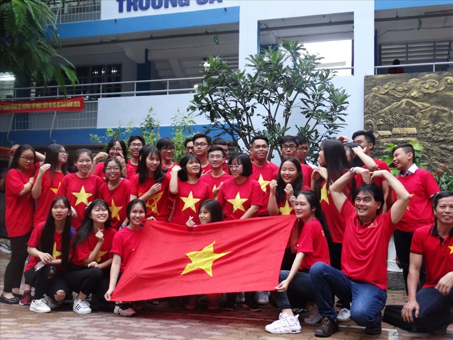 Các em học sinh thể hiện niềm tự hào chụp ảnh chung với Quốc kì.