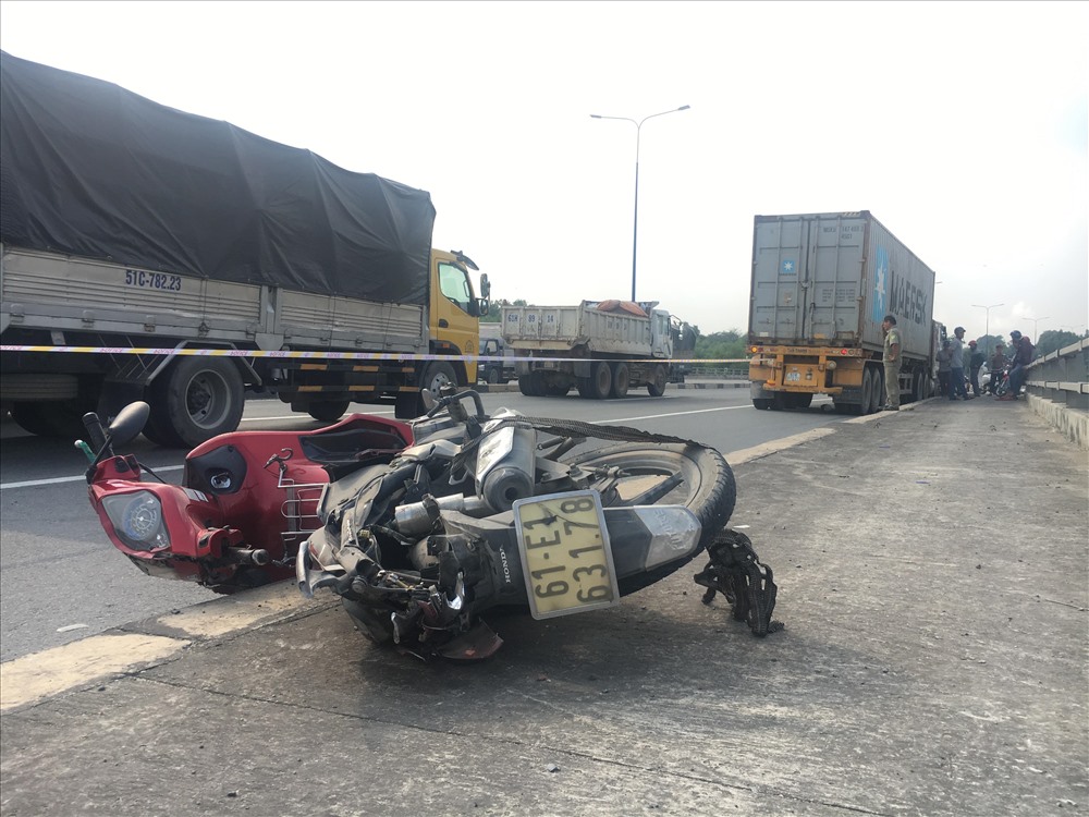 Xe máy bị hất văng lên phần đường cho người đi bộ trên cầu.