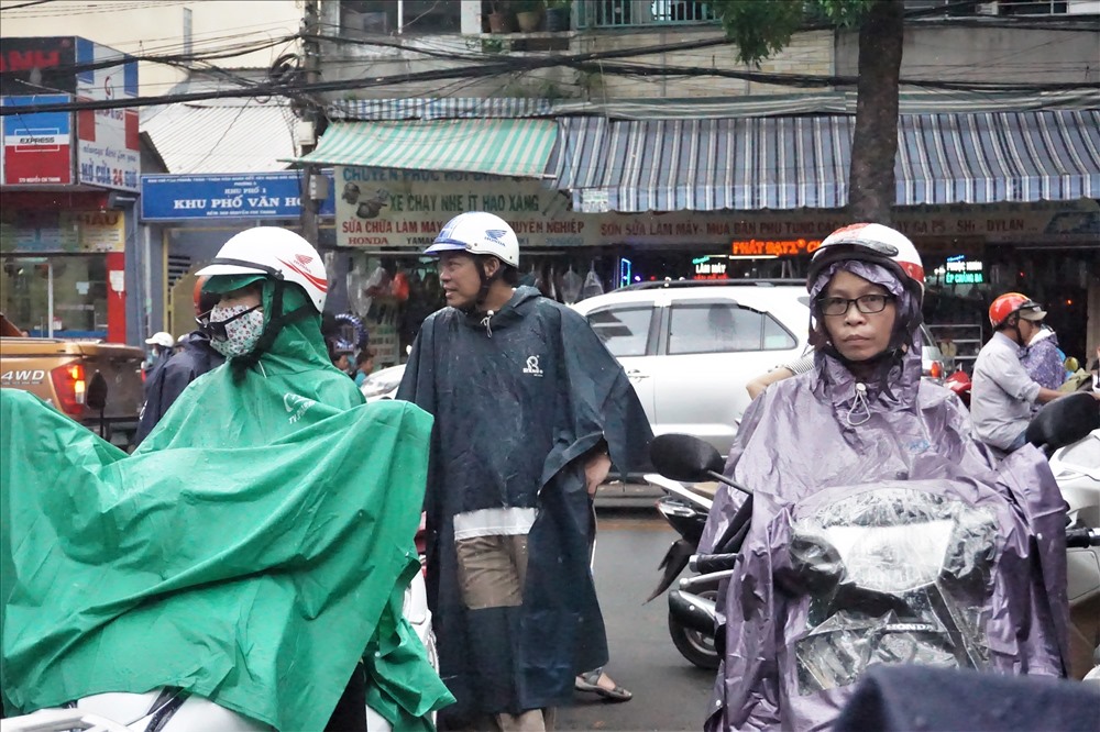 Phụ huynh đợi đón con em dưới trời mưa