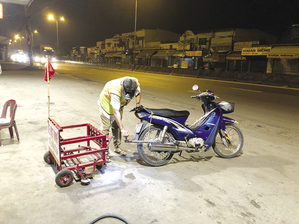 Đinh Minh Cảnh với chiếc xe hút đinh trên quốc lộ - Ảnh: ĐÌNH THẢO