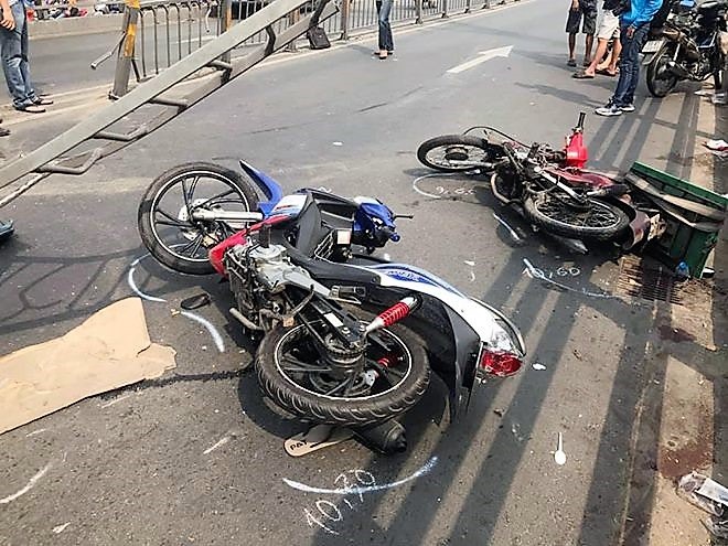 Bị dải phân cách văng trúng do xe tải húc, 2 người đi xe máy bị thương phải nhập viện cấp cứu. Ảnh: T.S