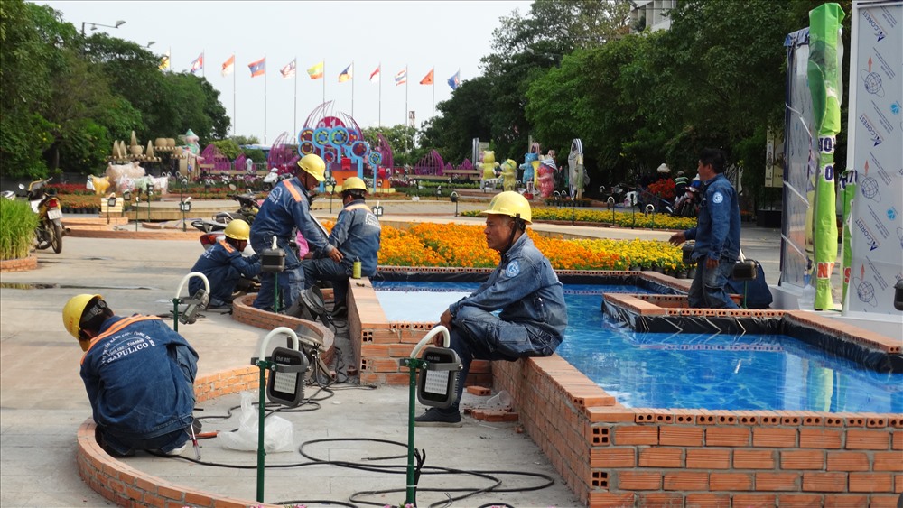Các công nhân điện lực đang lắp đặt và kiểm tra hệ thống đèn chiếu sáng.