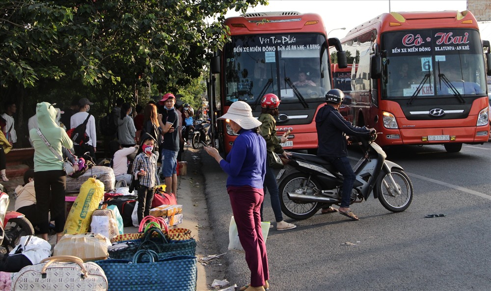 Chiều 25 Tết, hàng ngàn người lao động ở Bình Dương ra quốc lộ 13 đón xe về quê ăn Tết.