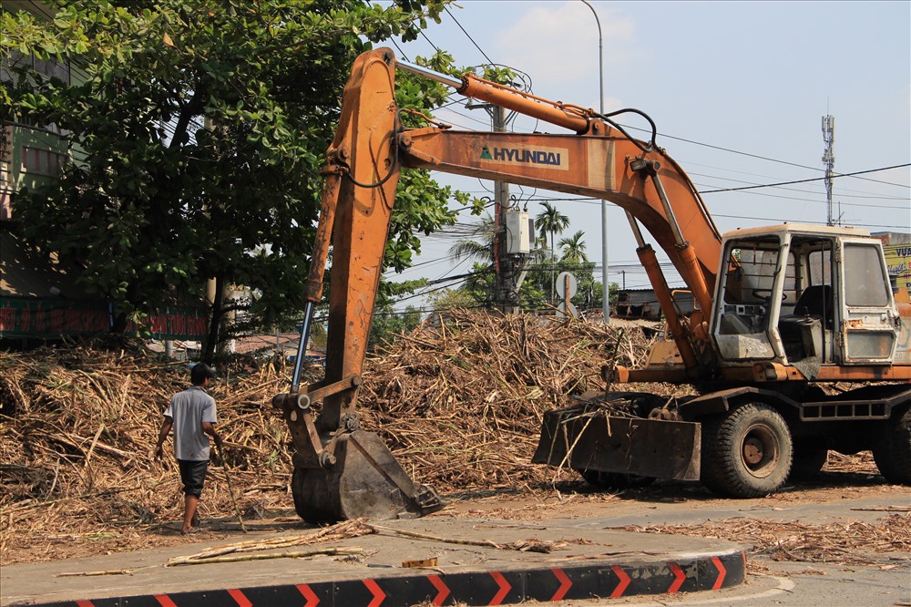 Đến 14h chiều, một xe máy múc và máy cẩu được điều động tới đưa phương tiện bị tai nạn đi và đẩy mía vào vỉa hè để thông tuyến đường..