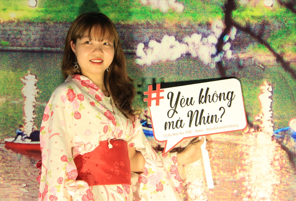 Giới trẻ mặc đồ truyền thống của Nhật Bản chụp hình bên bức tranh Hoa Đào.
