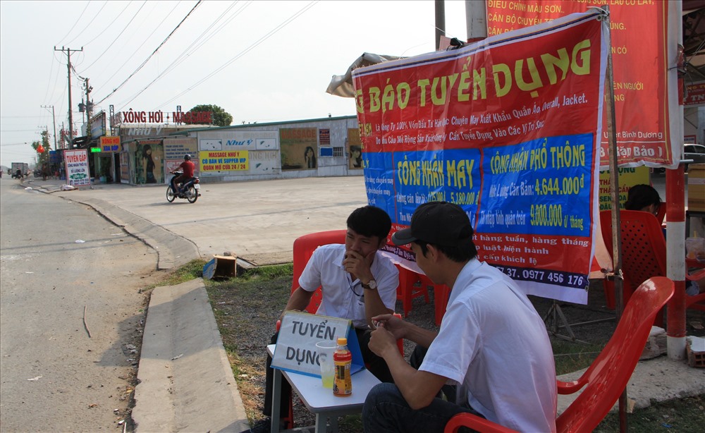 Nhân viên tuyển dụng ngồi chờ công nhân đến tìm việc làm.