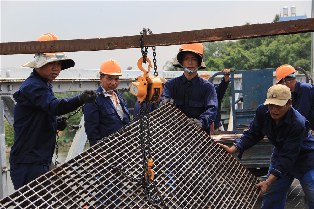 Từng tấm đan bằng sắt lát mặt cầu bị nhấc lên.